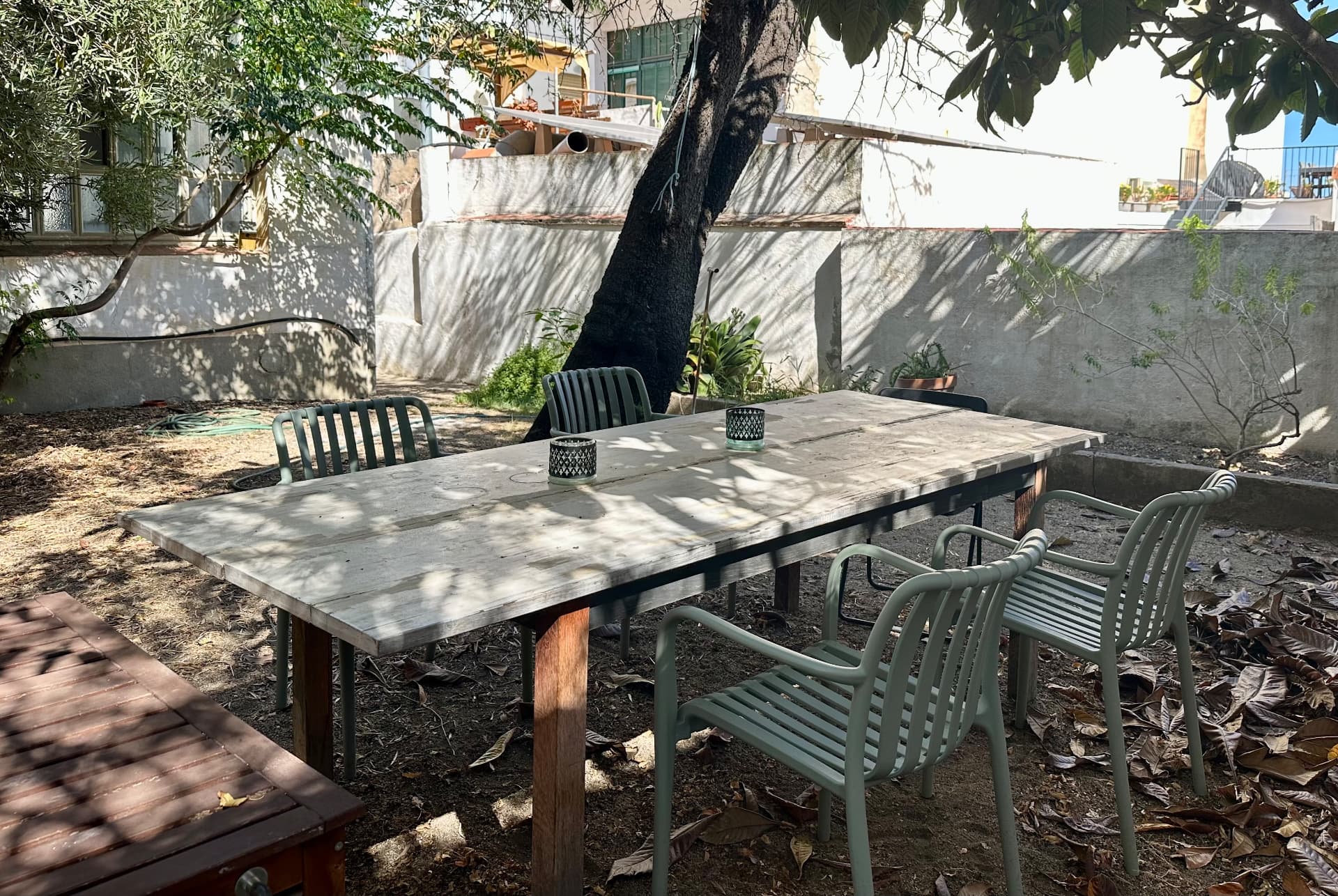 Mesa de trabajo al aire libre en el jardín, bajo el olivo y el níspero